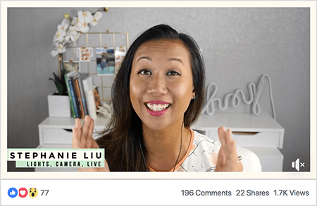 To je posnetek zaslona Stephanie Liu v videoposnetku v živo na Facebooku. Gledalci lahko vidijo Stephanie od ramen navzgor. Stephanie je Azijka s črnimi lasmi, ki visijo tik pod njenimi rameni. Nasmejana je in ima ličila ter belo srajco z breskovim in črnim abstraktnim vzorcem. Spodaj levo je na svetlo zelenem ozadju črno besedilo "Stephanie Liu, Lights Camera Live". Ozadje njenega videa v živo je siva soba z belo mizo. Na mizi so knjige in bela orhideja v kvadratnem belem loncu. Na mizi sedi tudi bel neonski napis z napisom "hej", ki je izklopljen. Video v živo ima 77 odzivov, 196 komentarjev, 22 delitev in 1,7 tisoč ogledov.