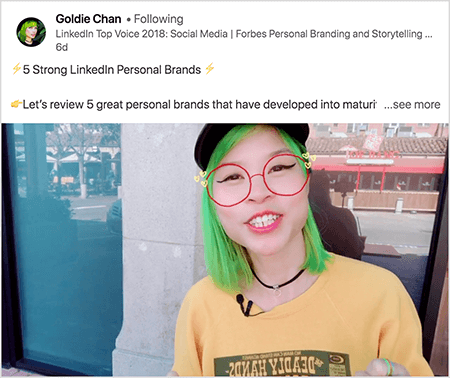 To je posnetek zaslona Goldie Chan, ki deli videoposnetek z jasnim odvzemom. V besedilu nad videoposnetkom piše "5 močnih osebnih znamk LinkedIn. Preglejmo 5 odličnih osebnih blagovnih znamk, ki so se razvile v zrelost.. Poglej več". Na video podobi se Goldie prikaže od skrinje navzgor. Je Azijka z zelenimi lasmi. Oblečena je v ličila, črno ogrlico iz čokerja in rumeno srajco. Videofilter kaže, da ima rdeča očala, narisana z markerjem.